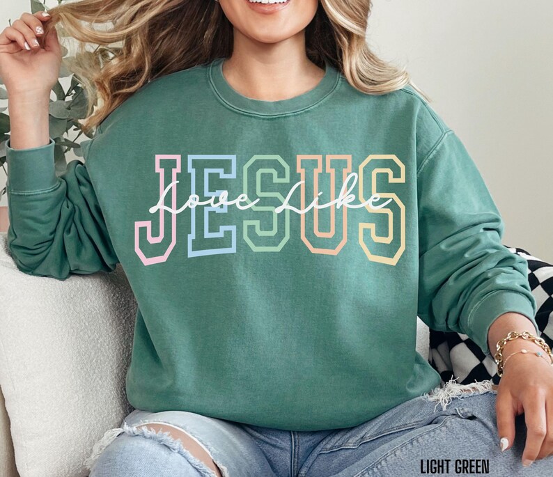 May include: A light green sweatshirt with the words "Love Like Jesus" in rainbow coloured letters.
