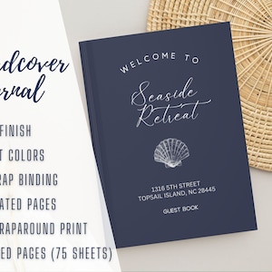 May include: A navy blue hardcover journal with the text "Welcome to Seaside Retreat" and a white seashell illustration. The journal has 150 lined pages (75 sheets) and is a guest book for a wedding or event.