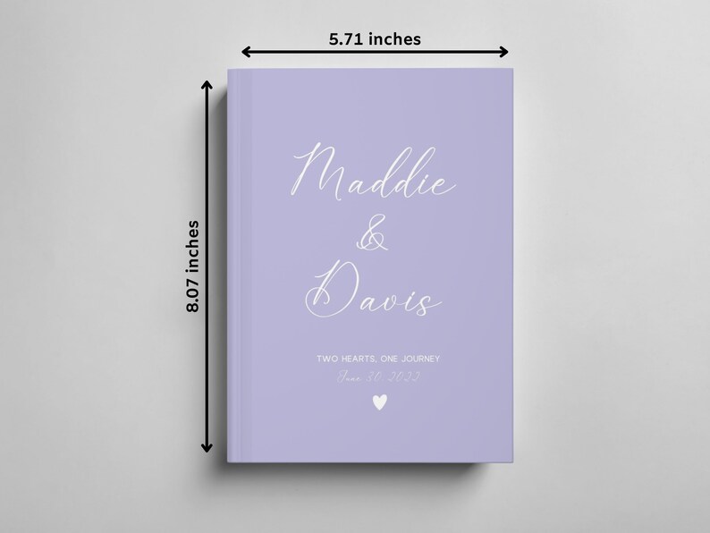 K&ouml;nnte beinhalten: Ein G&auml;stebuch in Lavendelfarbe mit den Namen "Maddie & Davis" in wei&szlig;er Kursivschrift. Der Text "Two Hearts, One Journey" und das Datum "June 30, 2023" sind ebenfalls in wei&szlig;er Kursivschrift. Das Buch misst 20,5 cm x 14,5 cm.