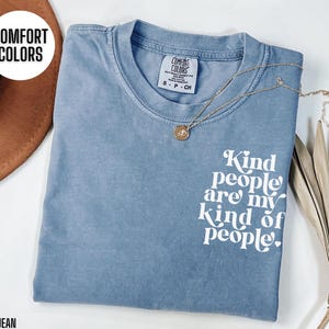 May include: A light blue t-shirt with the text "Kind people are my kind of people." printed in white. The shirt is made of a soft, comfortable material.