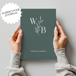 May include: A hardcover journal with a teal green cover featuring a white floral design and the initials "W" and "B" with the text "Weston & Birdie" below.