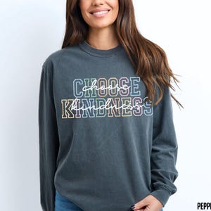May include: A dark gray long-sleeved t-shirt with the text "Choose Kindness" in rainbow colors.