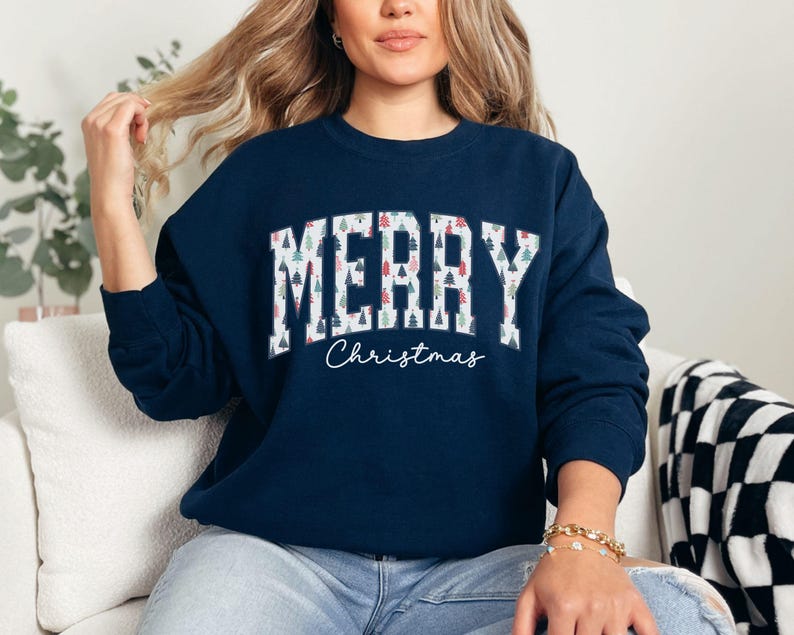 May include: A navy blue sweatshirt with a white "Merry Christmas" graphic. The text is made up of small Christmas trees.