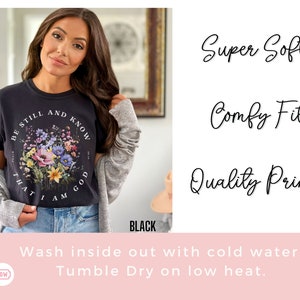 May include: Black t-shirt with a floral design and the text "Be Still and Know That I Am God". The shirt is super soft, comfy, and has a quality print. Wash inside out with cold water and tumble dry on low heat.