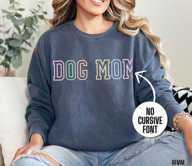 May include: A dark blue sweatshirt with the text "DOG MOM" in a rainbow colored block font.