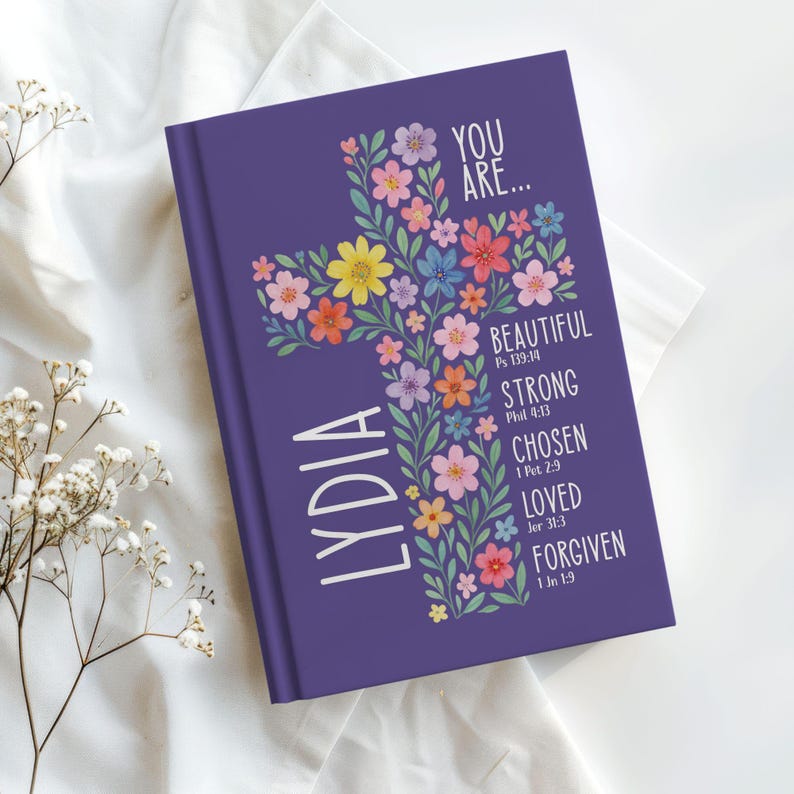 Personalized Christian journal for women and girls with a floral cross design on the cover. The front features “You Are” affirmations with Bible verses and a custom name option. Available in 8 colors, this faith-based notebook can be used for prayer journaling, Bible study notes, gratitude, reflections, and daily writing. Optional customization available for spine and back cover text. Feminine, inspirational gift idea for teens, women, church, or special occasions.