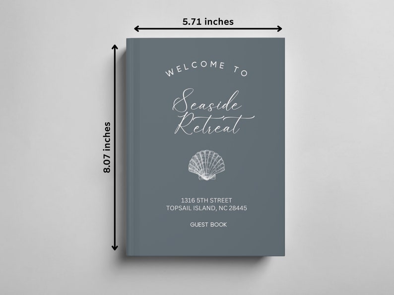 May include: A grey guest book with the text "Welcome to Seaside Retreat" in white script font. A white seashell illustration is below the text. The address "1316 5th Street Topsail Island, NC 28445" and the text "Guest Book" are also in white. The book measures 20.5 cm by 14.5 cm.