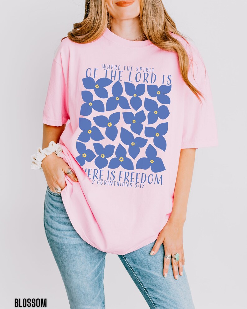 May include: Pink t-shirt with a blue floral design and the text "Where the Spirit of the Lord is, there is freedom. 2 Corinthians 3:17"