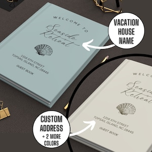 May include: Two light blue and beige guest books with a seashell design and the text "Welcome to Seaside Retreat" and "Vacation House Name". The address "1316 5th Street, Topsail Island, NC 28445" is printed on both books.