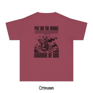 May include: Crimson red t-shirt with a black graphic print of a knight in armor riding a horse. The graphic includes the text "Put on the whole armour of God" and a bible verse reference.