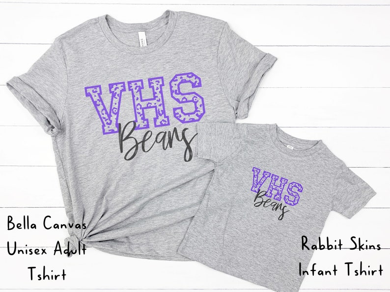 May include: Two gray t-shirts with the text "VHS Beans" in purple with a leopard print pattern. The larger shirt is a Bella Canvas Unisex Adult T-shirt. The smaller shirt is a Rabbit Skins Infant T-shirt.