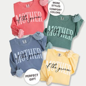 May include: Four crewneck sweatshirts in coral, green, blue, and yellow. Each shirt has "MOTHER of the groom" printed in white. The image also includes the text "MORE STYLES, COMFORT COLORS" and "PERFECT GIFT".