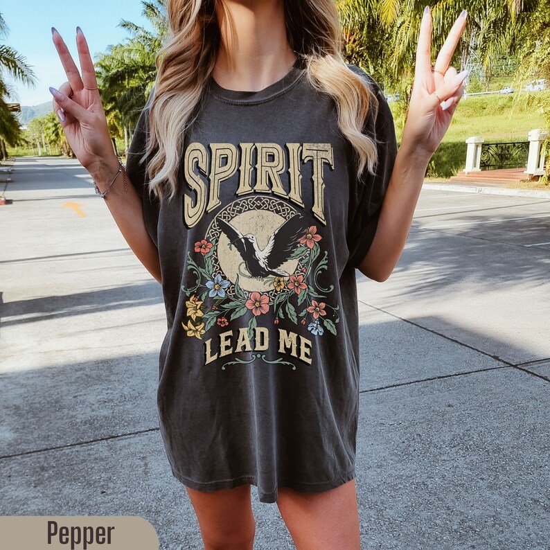 K&ouml;nnte beinhalten: Ein &uuml;berdimensioniertes, dunkelgraues T-Shirt mit einem Vintage-Druck eines fliegenden Adlers mit Blumen und dem Text "SPIRIT LEAD ME".