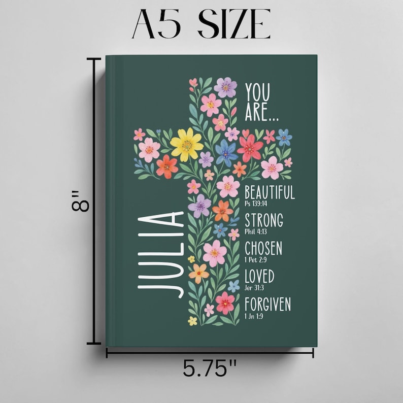 May include: A5 size journal with a dark green cover. The cover features a floral cross design with colorful flowers and the name "Julia" in white. Text includes "You Are... Beautiful, Strong, Chosen, Loved, Forgiven." The journal measures 8 inches tall and 5.75 inches wide.