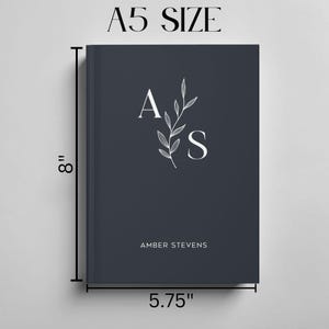 Może przedstawiać: Niebieski notes z inicjałami "A.S." i imieniem "Amber Stevens" nadrukowanym na biało. Notes ma 20,3 cm wysokości i 14,6 cm szerokości.