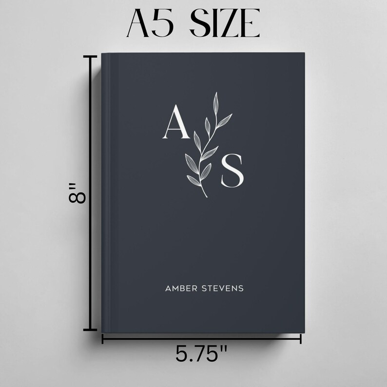 Może przedstawiać: Niebieski notes z inicjałami "A.S." i imieniem "Amber Stevens" nadrukowanym na biało. Notes ma 20,3 cm wysokości i 14,6 cm szerokości.