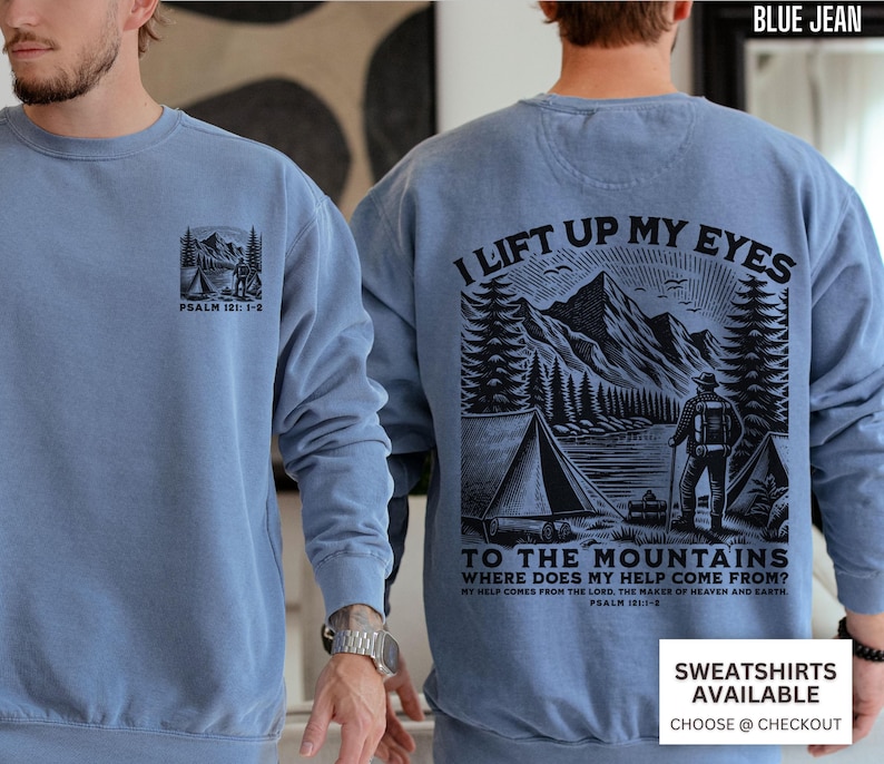 May include: A blue jean-colored sweatshirt with a mountain and tent graphic on the front and back. The front graphic includes the text "PSALM 121: 1-2". The back graphic features a mountain scene with the text "I LIFT UP MY EYES TO THE MOUNTAINS WHERE DOES MY HELP COME FROM?"