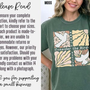 Op de afbeelding: Een groen T-shirt met een grafische print van een witte duif en bloemen. De tekst "Consider the Birds" en "Matthew 6:26" staat op het T-shirt gedrukt.