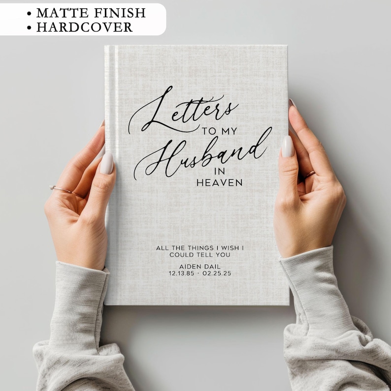 May include: A hardcover journal with a gray linen cover and black text that reads 'Letters to my Husband in Heaven.' The text below reads 'All the things I wish I could tell you.' The name 'Aiden Dail' and the dates '12.13.85 - 02.25.25' are printed below that.