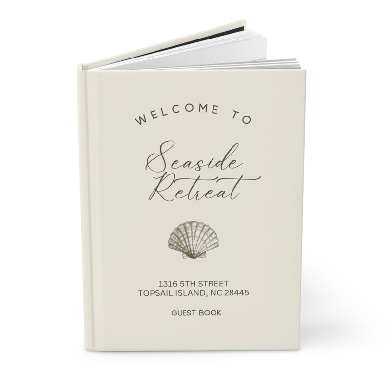 May include: A white guest book with the text "Welcome to Seaside Retreat" and a seashell illustration. The address "1316 5th Street, Topsail Island, NC 28445" and the words "Guest Book" are also printed on the cover.