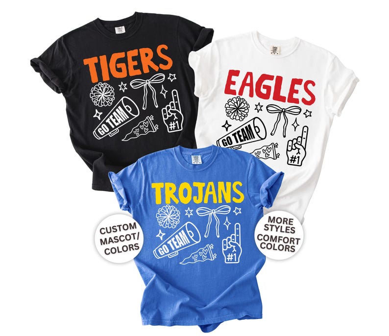 Personalized school spirit shirt displayed on a Comfort Colors garment featuring a custom school mascot name surrounded by colorful school spirit doodles. Buyers can personalize the mascot text and choose colors to match their school's team colors. Available as an adult Comfort Colors t-shirt, long sleeve tee, sweatshirt, and youth short sleeve tee. Perfect for football games, basketball season, pep rallies, spirit week, school events, and showing school pride all year long.