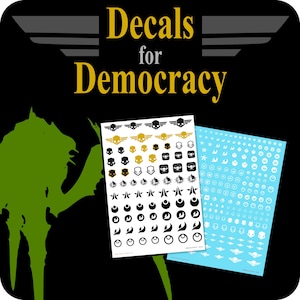 Pode incluir: Duas folhas de decalques com vários desenhos em preto, dourado e branco, incluindo caveiras, asas e formas geométricas. O texto "Decals for Democracy" está em letras douradas sobre um fundo preto. Uma folha é branca, a outra é azul claro.