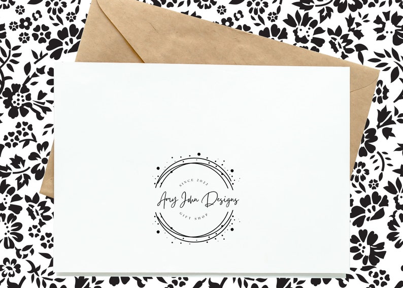 K&ouml;nnte beinhalten: Eine wei&szlig;e Karte mit einem schwarz-wei&szlig;en Logo, auf dem "Amy John Designs Gift Shop" in einem Kreis mit einer gepunkteten Linie steht. Das Logo befindet sich auf einem wei&szlig;en Hintergrund.