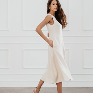 White modern sleeveless dress, form fitting shape with pockets for timeless and modern office look in midi length image 4