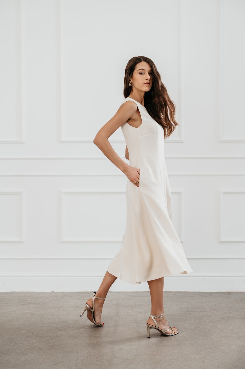 White modern sleeveless dress, form fitting shape with pockets for timeless and modern office look in midi length image 4