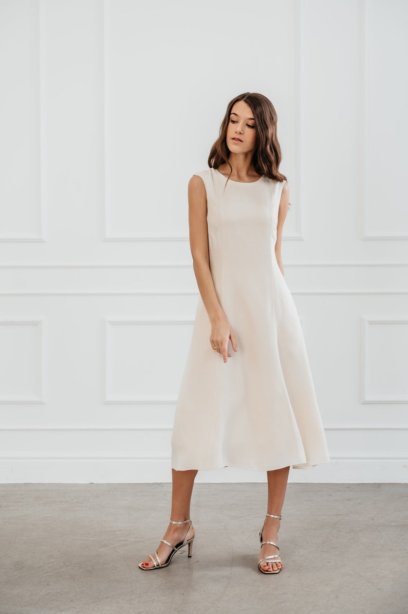 White modern sleeveless dress, form fitting shape with pockets for timeless and modern office look in midi length image 1