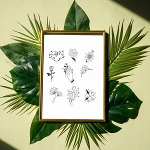 Może przedstawiać: Druk w złotej ramie z białym tłem i czarnymi rysunkami liniowymi różnych kwiatów i wzorów kwiatowych. Wzory obejmują serce, rękę trzymającą kwiat, kwiat z kółkiem wokół i kwiat z gwiazdą.