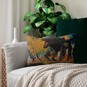 May include: Rectangular decorative pillow featuring a Godzilla-themed design. The artwork depicts a monster destroying a city with flames and a golden background. The pillow is placed on a gray sofa with a white blanket.