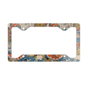 May include: A rectangular license plate frame featuring a repeating graphic print of orange and white koi fish swimming through stylized blue waves. The design includes subtle beige accents and Japanese text characters integrated into the artwork.