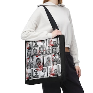 Puede incluir: Bolso tote negro con un collage de fotos policiales en blanco y negro con detalles de salpicaduras rojas. El bolso tiene una correa negra para el hombro. La persona lleva una sudadera con capucha blanca y pantalones negros.