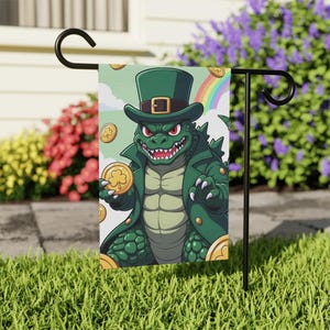 Puede incluir: Una bandera de jardín del Día de San Patricio con un cocodrilo de dibujos animados con un sombrero de copa y abrigo verdes, sosteniendo una moneda de oro con un trébol. La bandera tiene un arcoíris y monedas de oro en el fondo.
