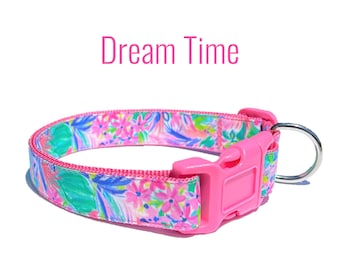 May include: Pink dog collar with a floral print and a pink buckle. The collar has the text "Dream Time" printed on it.