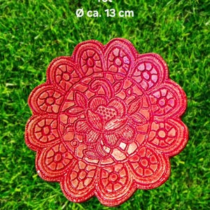 Könnte beinhalten: Ein rotes, dekoratives Vogelbad oder Insektenwasserbecken mit floralem Design. Der Text auf dem Bild lautet "Vogel-/ Insektentränke rot" und "ø ca. 13 cm", was etwa 13 cm Durchmesser entspricht. Das Vogelbad befindet sich auf einer grünen, grasbewachsenen Oberfläche.