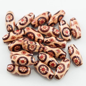 May include: A collection of wooden beads with a geometric pattern in shades of brown and red. The beads are oval shaped and have a smooth, polished finish.