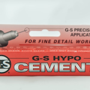 Puede incluir: Un tubo rojo de cemento G-S Hypo con una etiqueta blanca y texto negro. La etiqueta dice "G-S Precision Applicator" y "For Fine Detail Work".