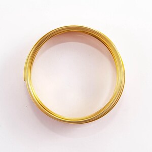 Puede incluir: Una bobina de alambre de color dorado, ideal para la elaboración de joyas u otros proyectos.