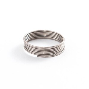 May include: A coil of silver-colored wire, wrapped into a circle.