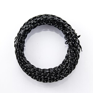 May include: A coil of black floral wire, suitable for floristry and crafts. The wire is tightly twisted, offering a decorative and robust material. The dark hue provides a neutral base for various projects.
