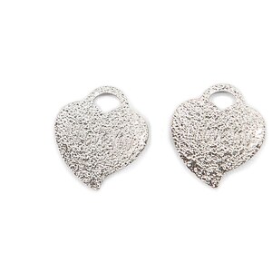 May include: Two silver heart-shaped charms with a textured surface and a hole at the top for attaching to jewelry or other crafts.