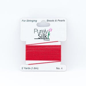May include: Red silk thread for stringing beads and pearls, 2 yards (1.8 meters) long, labeled "Purely Silk Thread" and "No. 4".