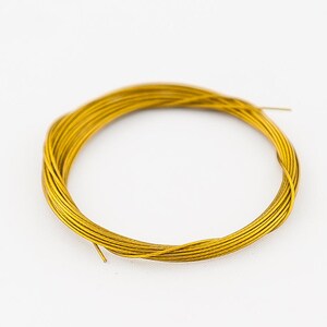 Pode incluir: Uma bobina de fio dourado, ideal para artesanato e fabricação de joias.
