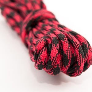 May include: Red and black patterned shoelaces, coiled and ready to be used.