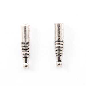 Op de afbeelding: Twee zilverkleurige metalen kralen met een cilindrische bovenkant en een geribbeld, taps toelopend lichaam. Elke kraal heeft een klein, afgerond uiteinde. De kralen worden getoond tegen een witte achtergrond.