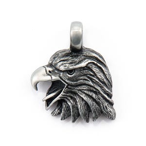 May include: A silver eagle head pendant charm. The eagle's beak is open and its eyes are visible. The pendant is detailed and realistic.