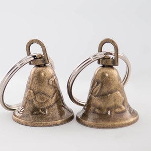Clochettes en laiton avec motif lapin et oiseau et vrai battant, métal, 23 x 20 mm, avec anneau brisé 25 mm, 2 unités