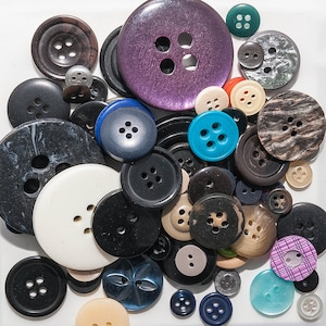 May include: Assortment of colorful buttons in various shapes, sizes, and patterns.  The buttons are made of different materials, including plastic, metal, and wood.  Some buttons have a shiny finish, while others have a matte finish.